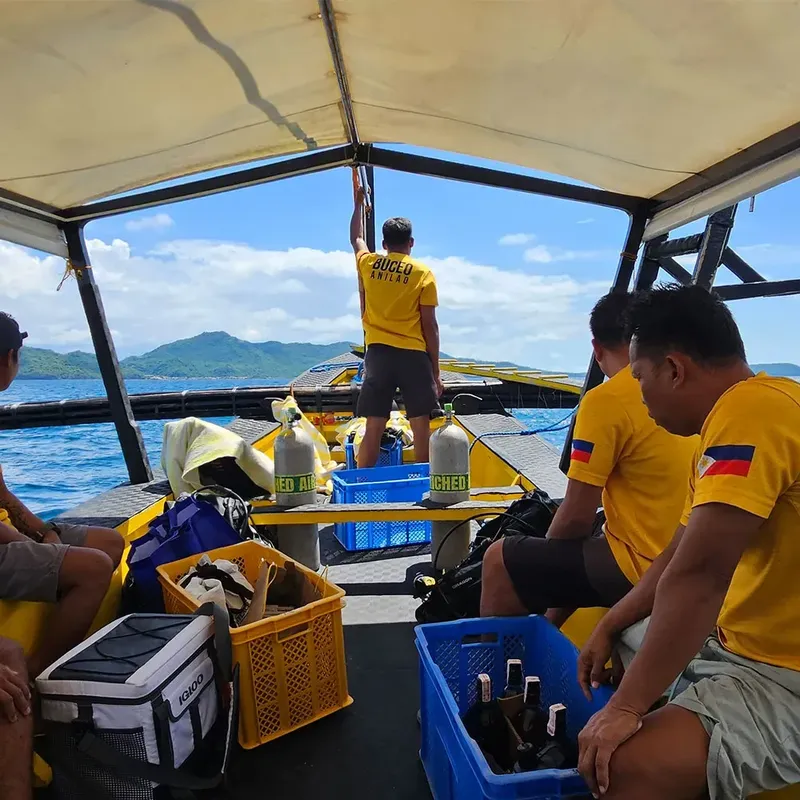 Personnes à bord d'un bateau de plongée avec des bouteilles et équipement