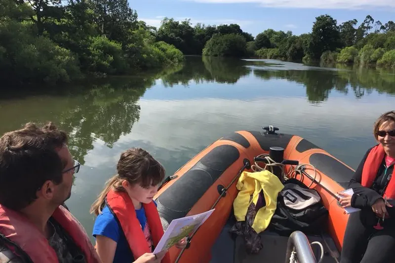 Personnes à bord d'un bateau pneumatique sur une rivière calme