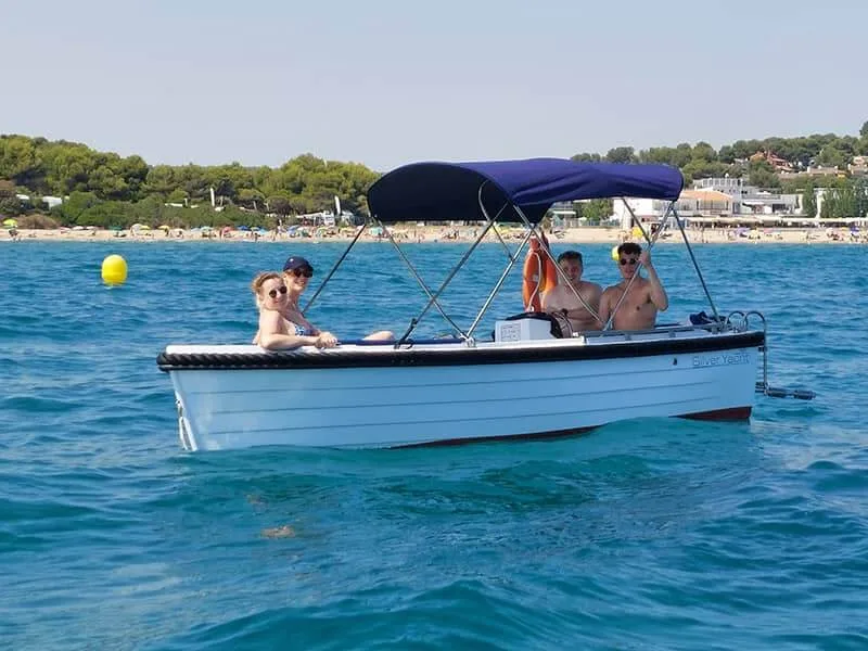 Quatre personnes sourient à bord d'un petit bateau en mer