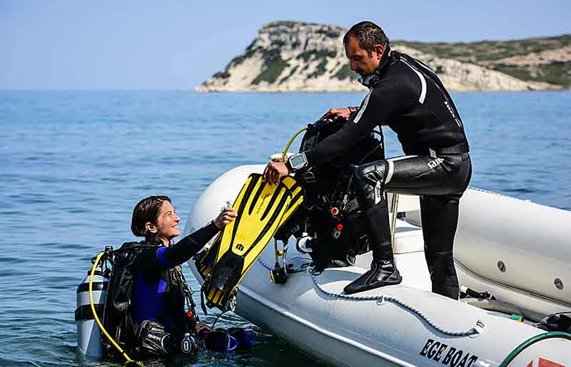 Deux plongeurs s'équipent sur un bateau pneumatique en mer