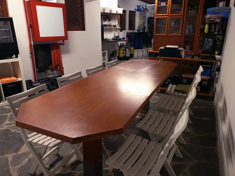 Intérieur d'un centre de plongée avec table, chaises et équipement