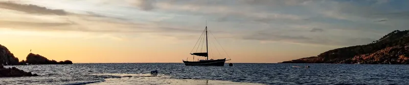 Voilier au coucher du soleil sur une mer calme et paisible