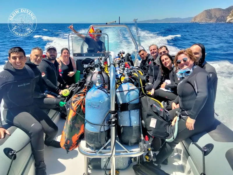 Groupe de plongeurs souriants sur un bateau semi-rigide en mer