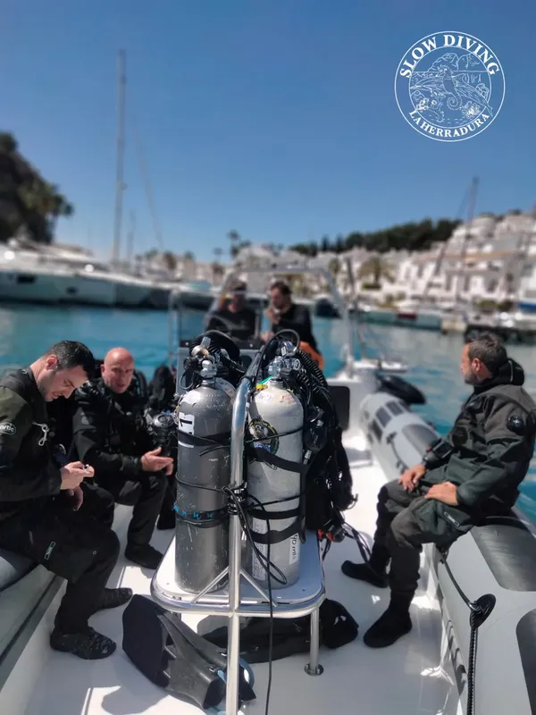 Plongeurs préparant leur matériel à bord d'un bateau pneumatique en mer