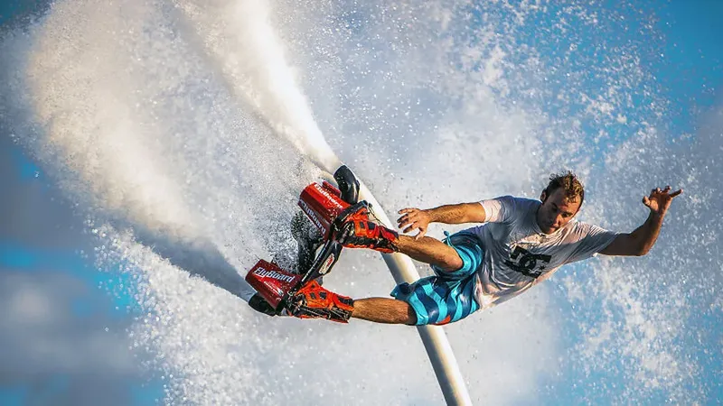 Homme pratiquant le flyboard au-dessus de l'eau avec des projections