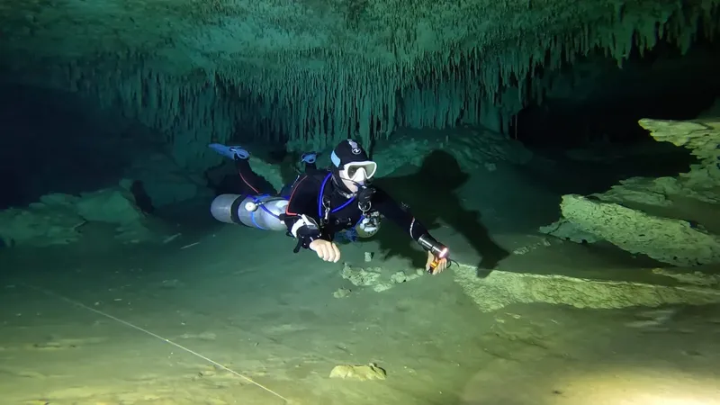 Plongeur explore une grotte sous-marine éclairée par une lampe torche