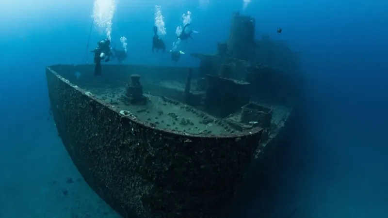Plongeurs explorant l'épave d'un navire sous l'eau, lumière bleutée