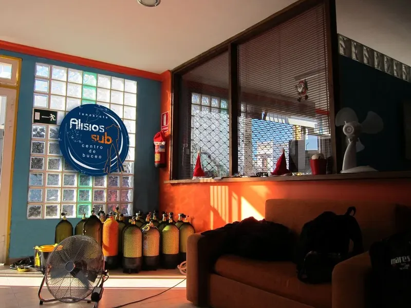 Intérieur d'un centre de plongée avec bouteilles et logo bleu