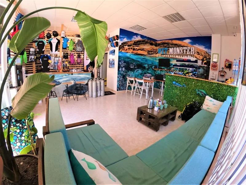Intérieur d'un centre de plongée avec matériel, canapés et mur décoratif