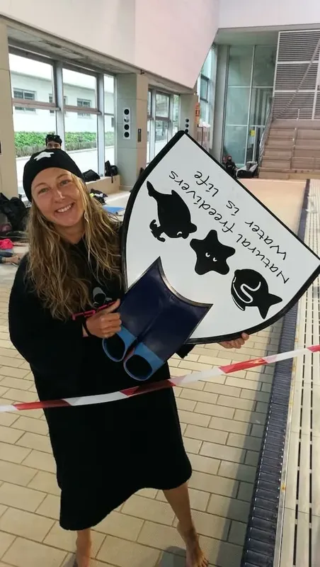 Femme souriante tenant un panneau avec des dessins de poissons