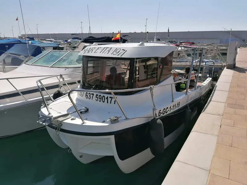 Bateau de plongée amarré à quai avec des personnes à bord
