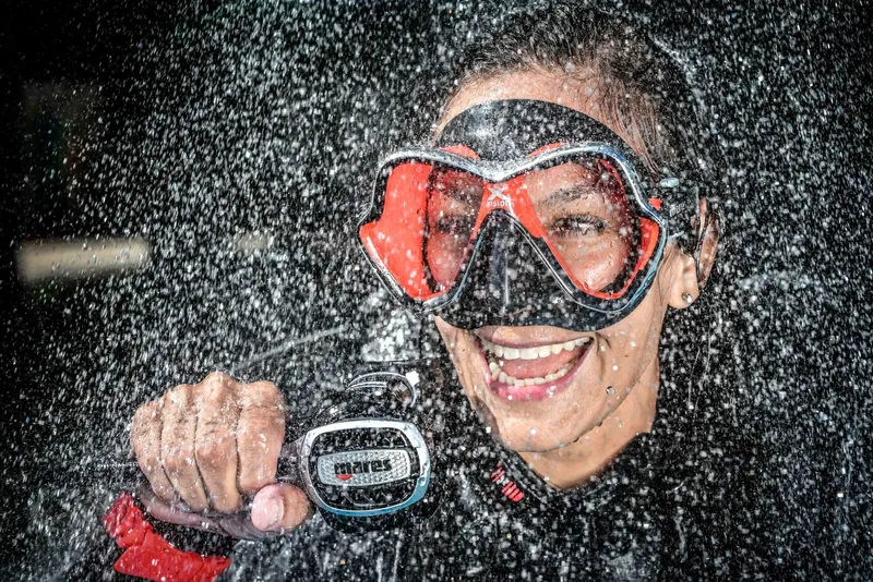 Plongeur souriant avec masque et détendeur, éclaboussures d'eau, portrait dynamique