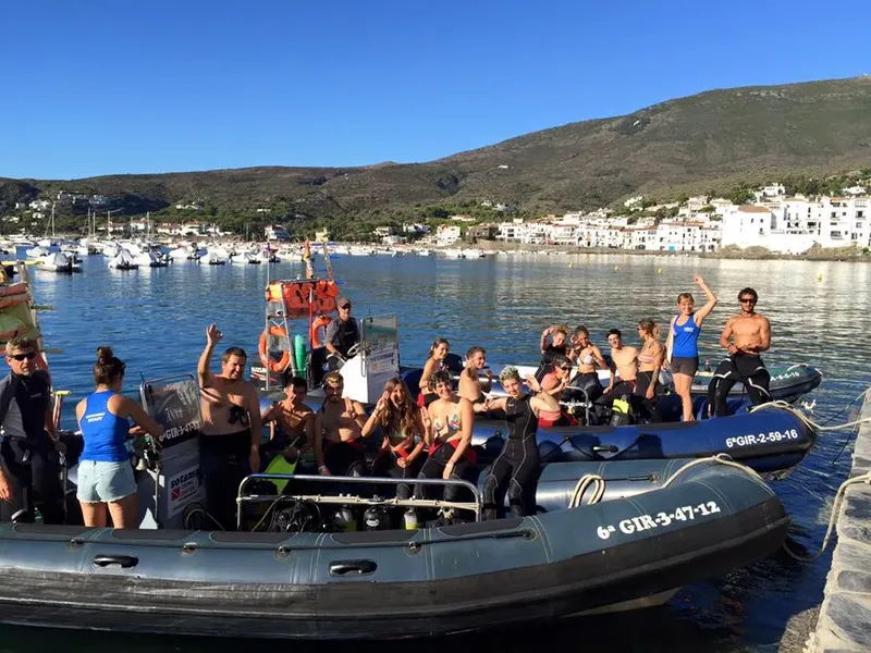 Groupe de plongeurs souriants sur un bateau pneumatique au port