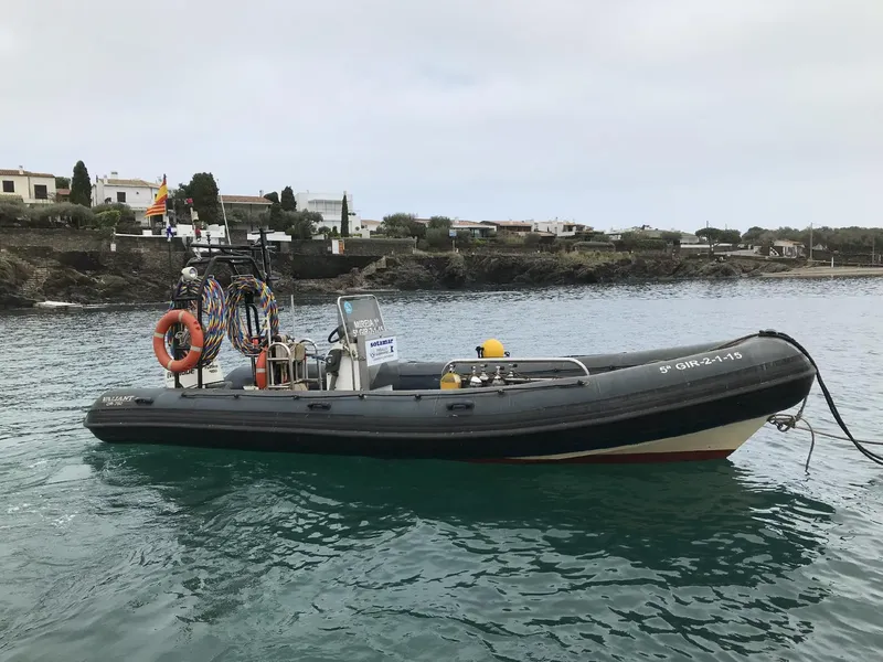 Bateau semi-rigide amarré sur une eau calme avec du matériel de plongée