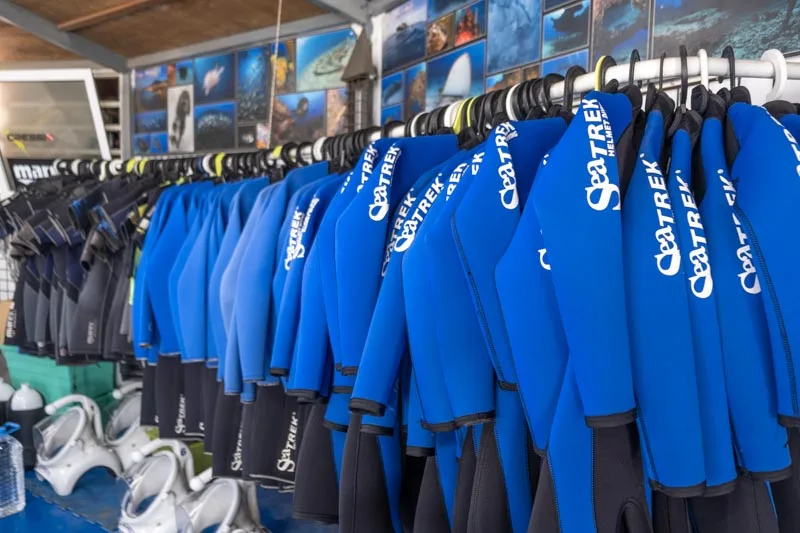 Rangées de combinaisons de plongée bleues SeaTrek suspendues dans un centre