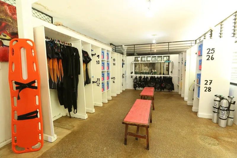Vestiaires du centre avec rangements, combinaisons et bouteilles de plongée
