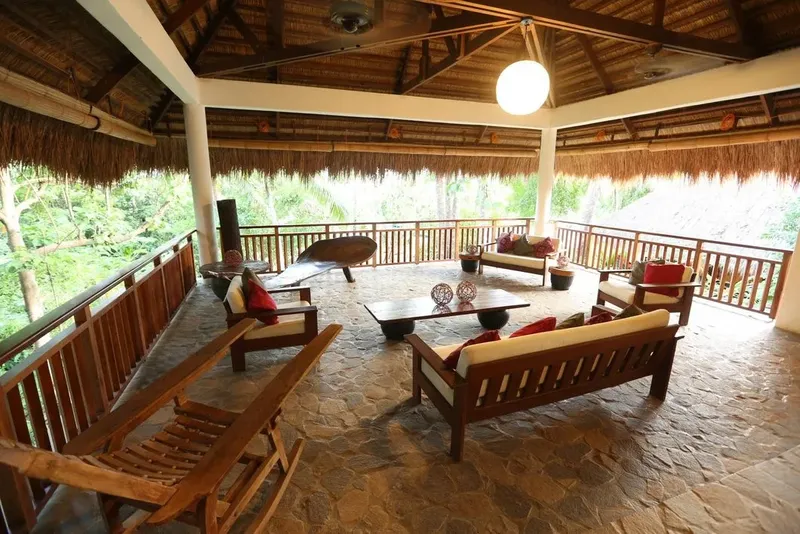 Espace détente extérieur avec mobilier en bois et végétation luxuriante