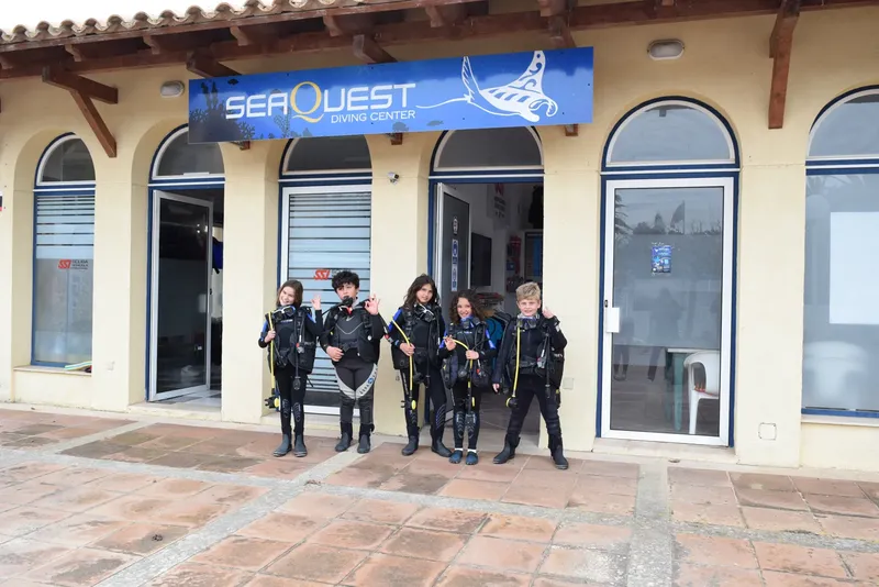 Groupe de plongeurs équipés devant la façade d'un centre