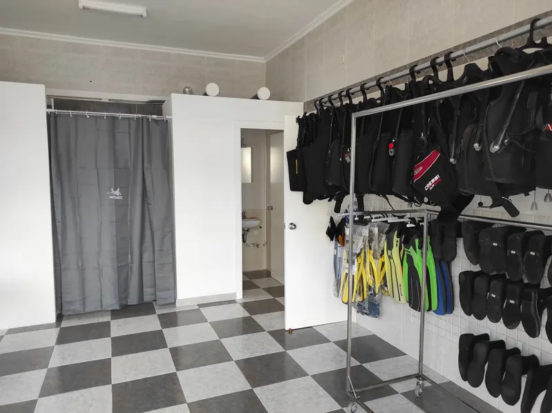 Salle de stockage avec combinaisons, gilets et palmes de plongée