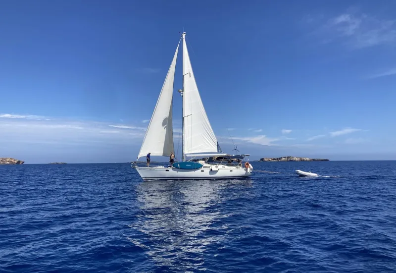 Voilier blanc naviguant sur une mer bleue sous un ciel clair