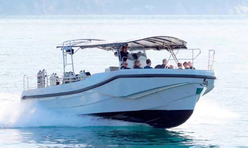 Bateau de plongée blanc avec des passagers et des bouteilles à bord