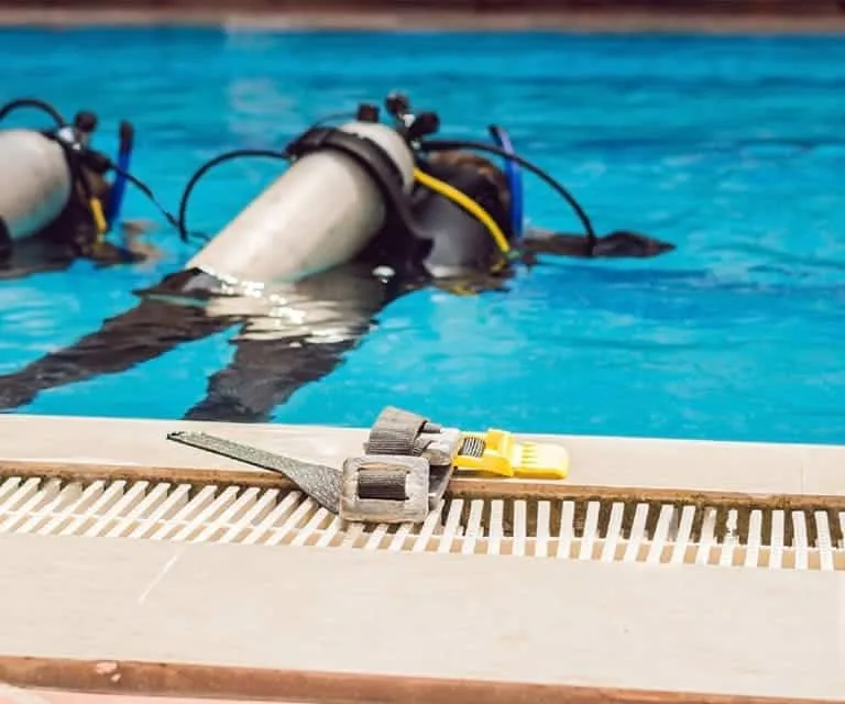 Plongeurs en formation dans une piscine avec équipement complet