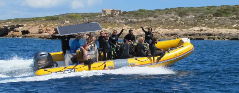 Groupe de plongeurs à bord d'un bateau semi-rigide en mer