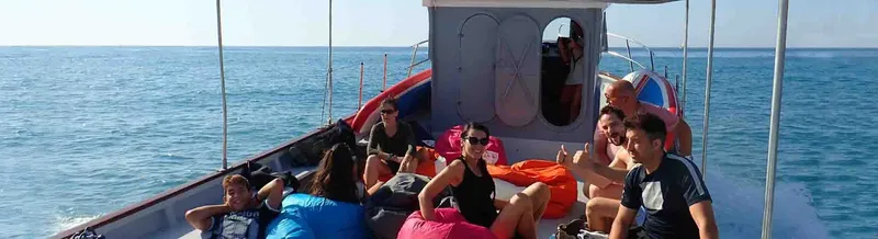 Groupe de personnes souriantes sur un bateau de plongée en mer