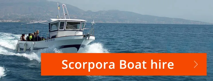 Bateau de plongée en mer avec des passagers et un fond montagneux