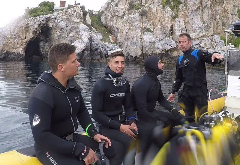 Plongeurs en combinaison sur un bateau jaune, prêts pour une sortie
