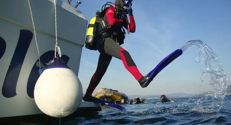 Plongeur s'apprête à entrer dans l'eau depuis un bateau de plongée