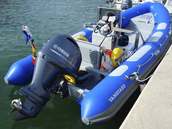 Bateau semi-rigide bleu amarré à un quai avec un moteur Yamaha