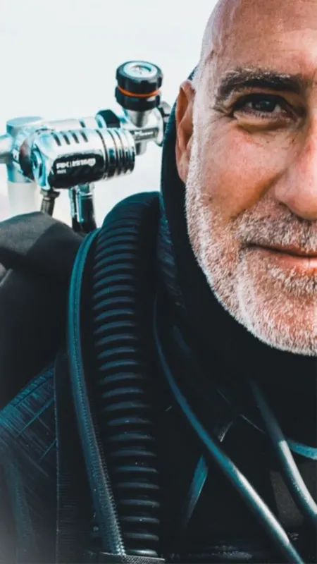 Plongeur souriant avec détendeur et gilet, portrait rapproché