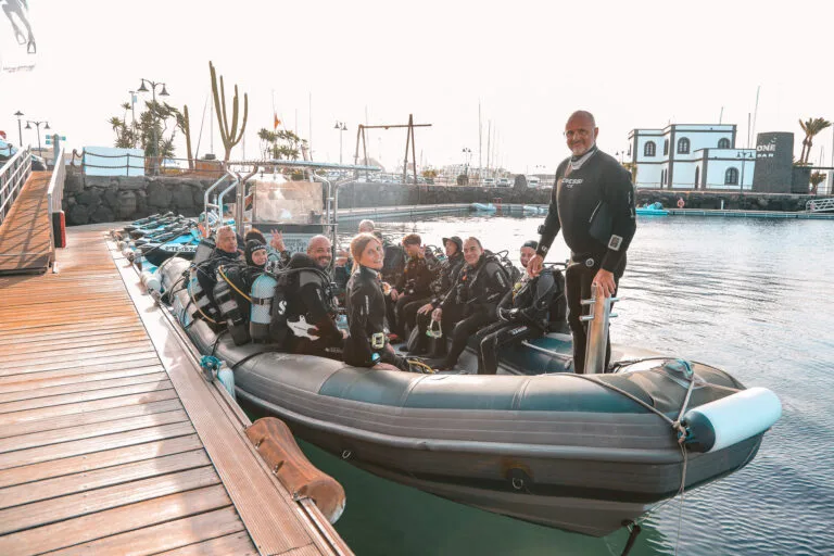 Groupe de plongeurs sur un bateau semi-rigide au port