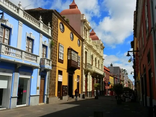 Rue colorée avec bâtiments anciens et quelques passants ensoleillés