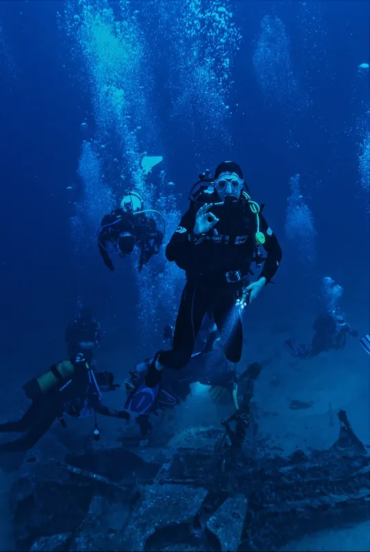 Plongeurs explorent une épave sous-marine dans l'eau bleue