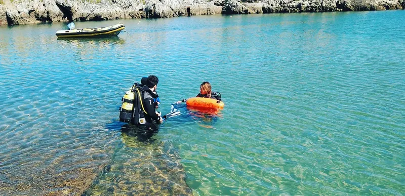 Deux plongeurs s'équipent dans une eau claire près d'un bateau