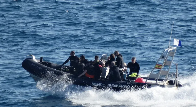 Groupe de plongeurs sur un bateau semi-rigide en pleine mer