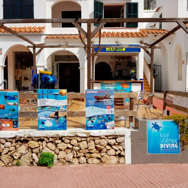 Devanture d'un centre de plongée avec affiches et enseigne bleue