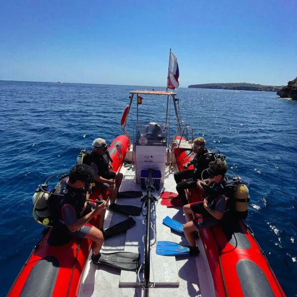 Plongeurs équipés sur un bateau semi-rigide en pleine mer
