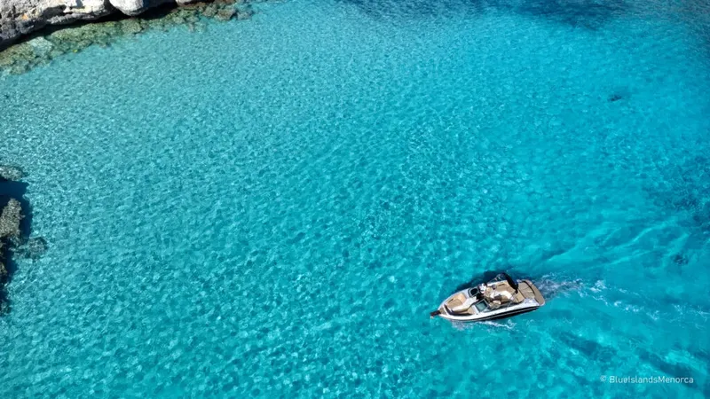Bateau de plaisance naviguant dans une eau turquoise claire et limpide