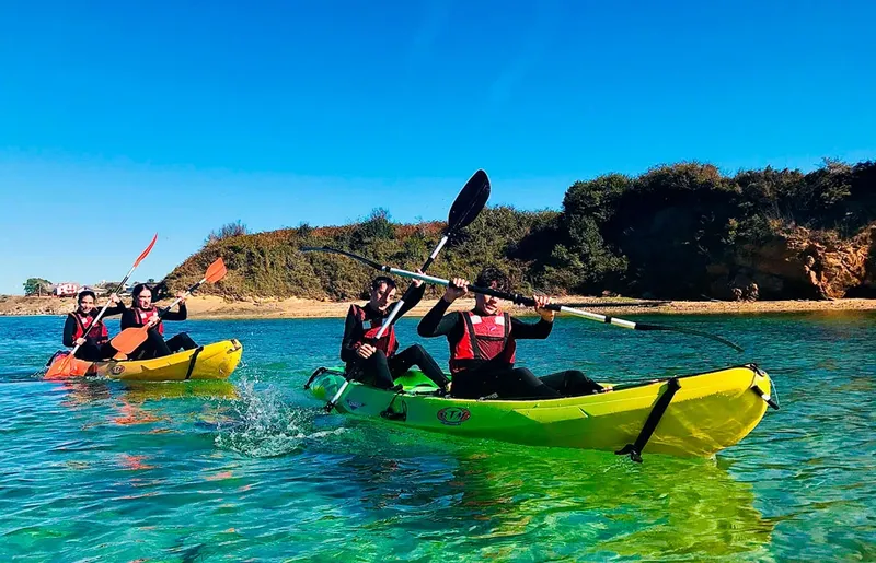 Quatre personnes pagayent en kayak sur une eau turquoise claire