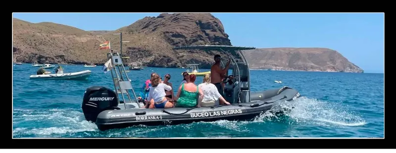 Bateau semi-rigide en mer avec des passagers et un paysage côtier