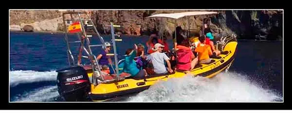 Groupe de plongeurs à bord d'un bateau semi-rigide jaune en mer