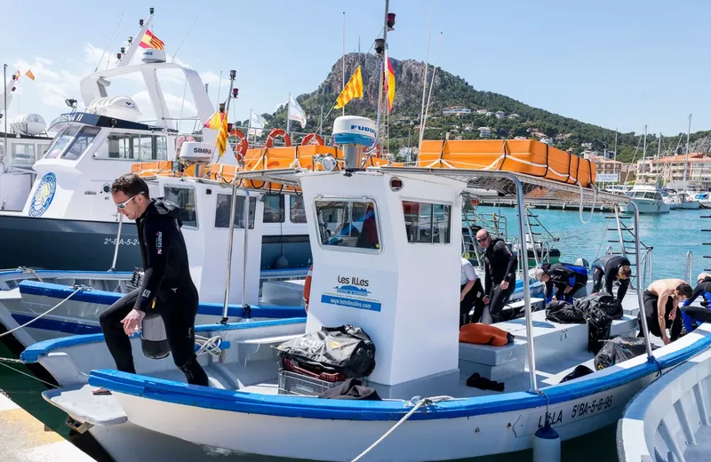 Plongeurs équipés montent à bord d'un bateau dans un port ensoleillé