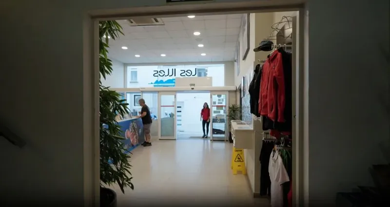 Intérieur d'un centre de plongée avec comptoir d'accueil et vêtements