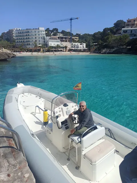 Homme assis au volant d'un bateau semi-rigide dans une crique turquoise