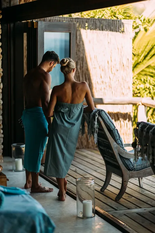 Couple se tenant par la main sur une terrasse en bois