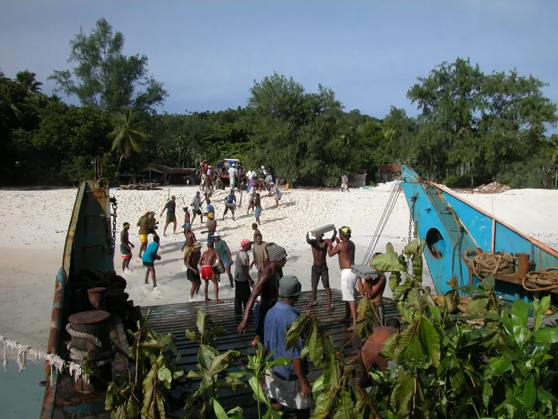 Groupe de personnes sur une plage et un bateau en bois