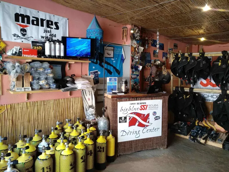 Intérieur d'un centre de plongée avec matériel, bouteilles et comptoir d'accueil